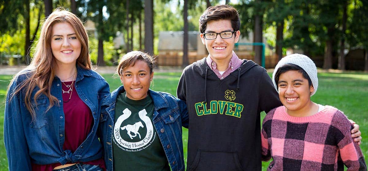 Four 4-H'ers standing arm-in-arm.